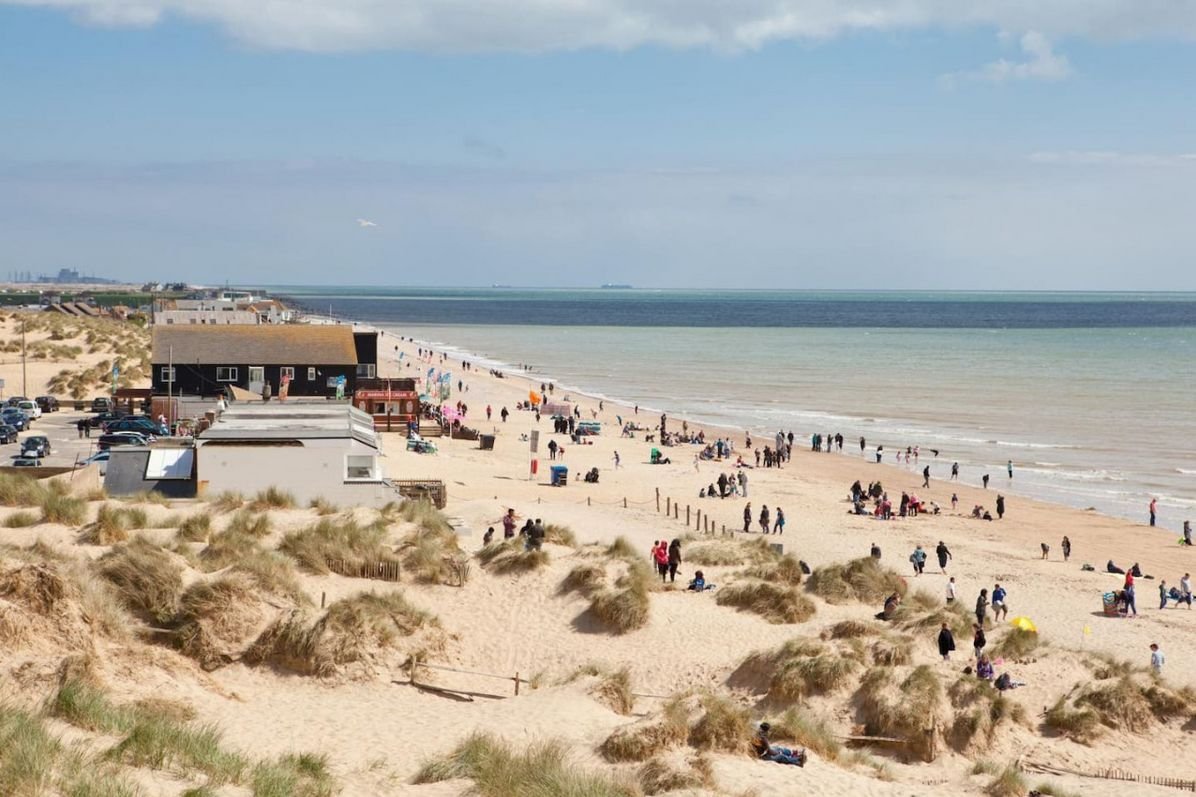 Camber Sands beach on a summer day with families on the golden sand and dunes